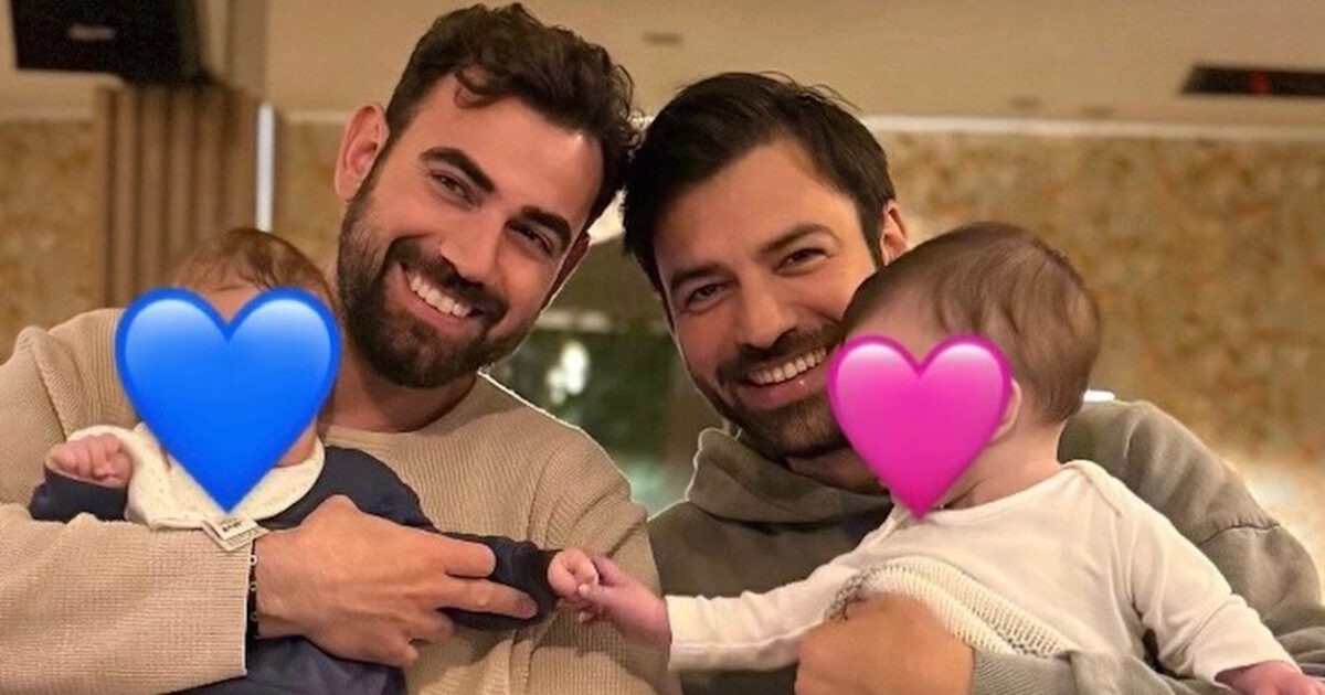 O Αντρέας Γεωργίου και ο Νίκος Πολυδερόπουλος ποζάρουν μαζί, κρατώντας τα μωρά τους αγκαλιά