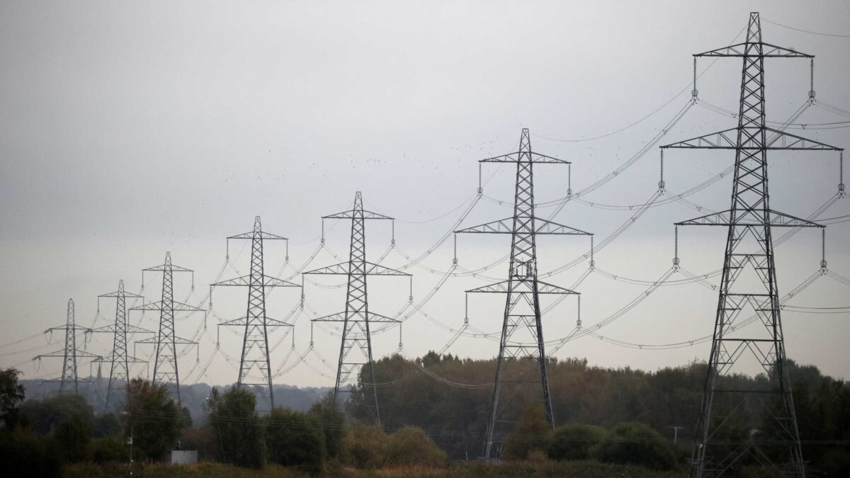 FILE PHOTO: Sheep graze beneath a row of electricity pylons near Ellesmere Port, Britain, October 11, 2021.