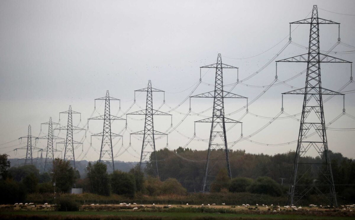 FILE PHOTO: Sheep graze beneath a row of electricity pylons near Ellesmere Port, Britain, October 11, 2021.