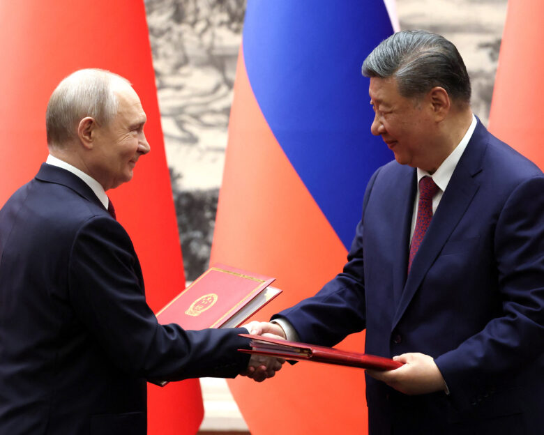 Russian President Vladimir Putin and Chinese President Xi Jinping shake hands during a signing ceremony at the Great Hall of the People in Beijing, China May 20, 2026.
