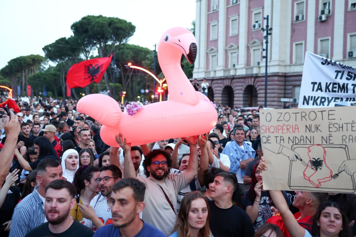 Διαδηλωτές κρατούν πανό, φλαμίνγκο και την αλβανική σημαία καθώς διαμαρτύρονται για το πολυτελές θέρετρο, που συνδέεται με τον γαμπρό του Ντόναλντ Τραμπ, Τζάρεντ Κούσνερ, σε προστατευόμενη περιοχή στα Τίρανα της Αλβανίας