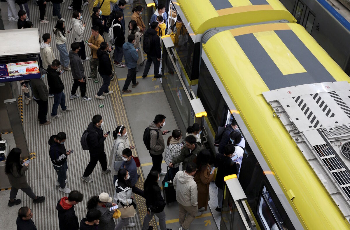 FILE PHOTO: Commuters line up to board a train at a subway station near the Zhongguancun tech hub, during morning rush hour in Beijing, China March 27, 2025.