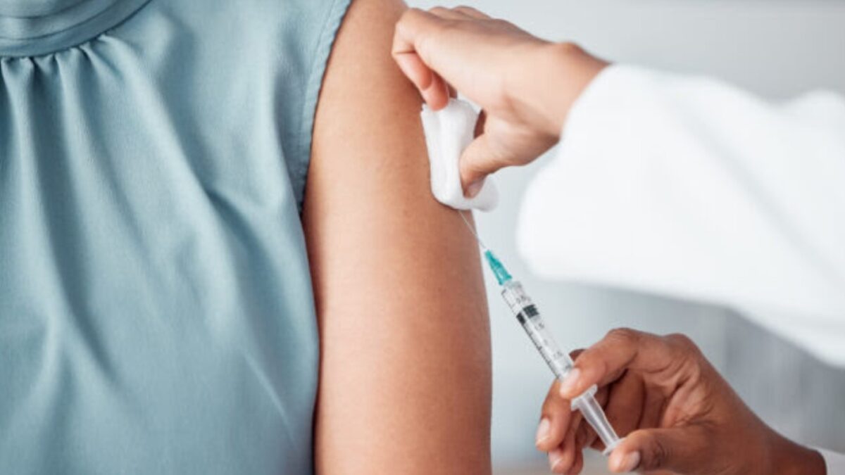 Hands, medical and doctor with patient for vaccine in a clinic for healthcare treatment for prevention. Closeup of a nurse doing a vaccination injection with a needle syringe in a medicare hospital.