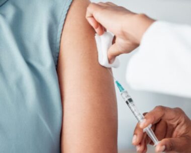 Hands, medical and doctor with patient for vaccine in a clinic for healthcare treatment for prevention. Closeup of a nurse doing a vaccination injection with a needle syringe in a medicare hospital.