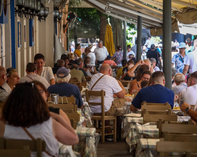 Πλήθος τουριστών επισκέπτονται την Αθήνα, δημοφιλής τουριστικός προορισμός η συνοικία της Πλάκας, όπου καταστήματα με τουριστικά ήδη και καταστήματα εστίασης είναι γεμάτα.