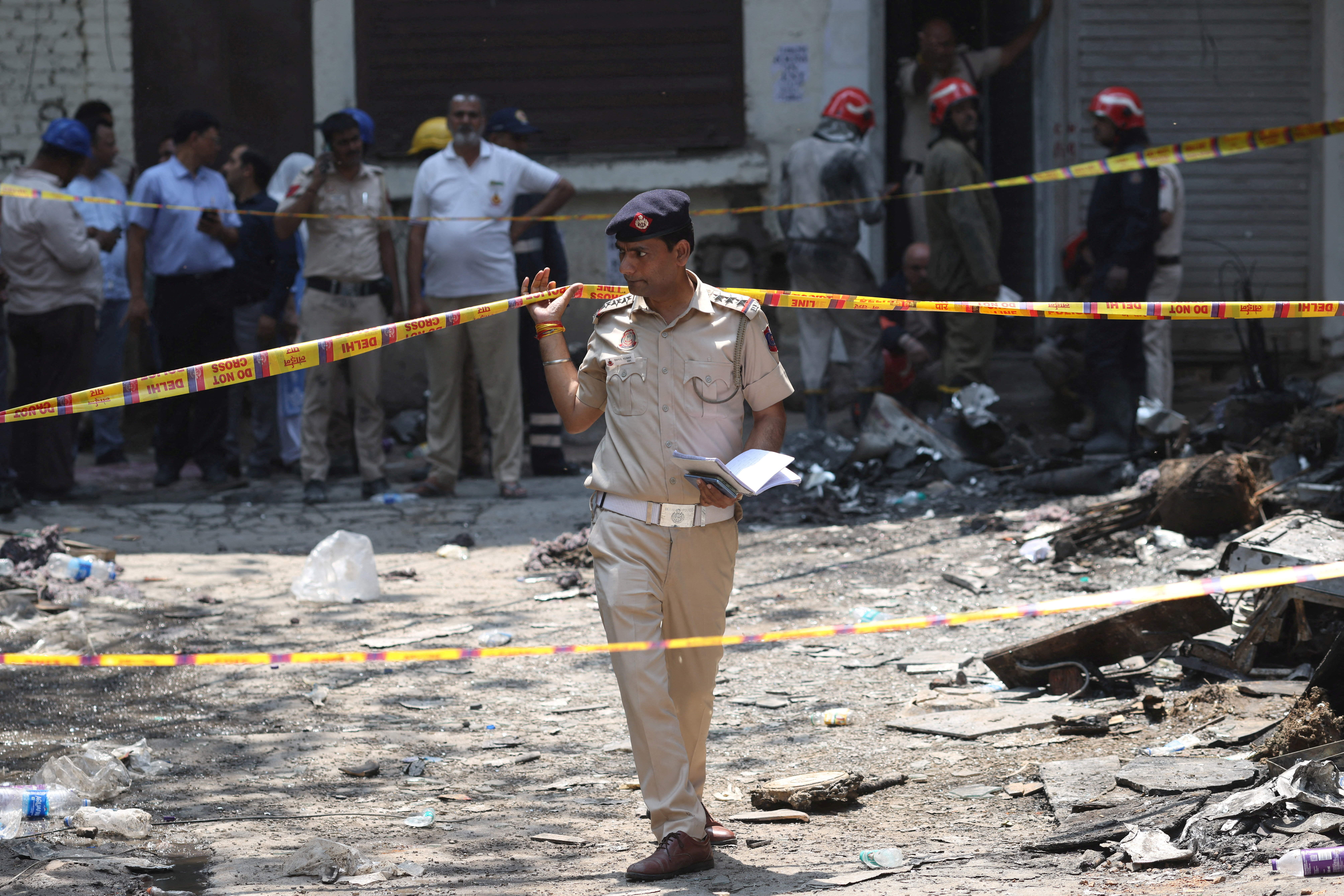 A police officer walks in between security tapes at the spot after a fire at a hotel in New Delhi, India, June 3, 2026. REUTERS/Adnan Abidi
