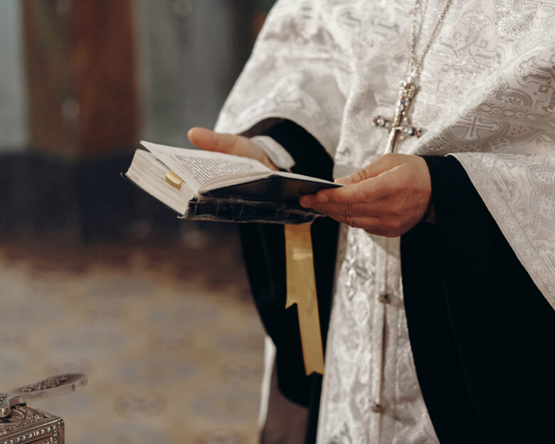 Priest reading holy bible in christian church during orthodox wedding ceremony, spiritual ritual concept