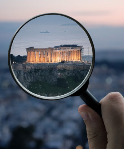 A magnifying glass over the Parthenon building in Athens, Greece