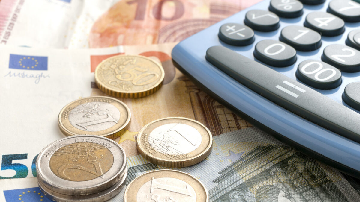 Euro coins on euro banknotes and a calculator