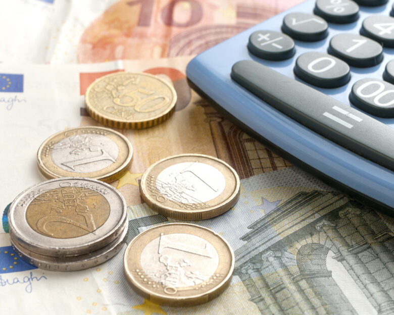 Euro coins on euro banknotes and a calculator