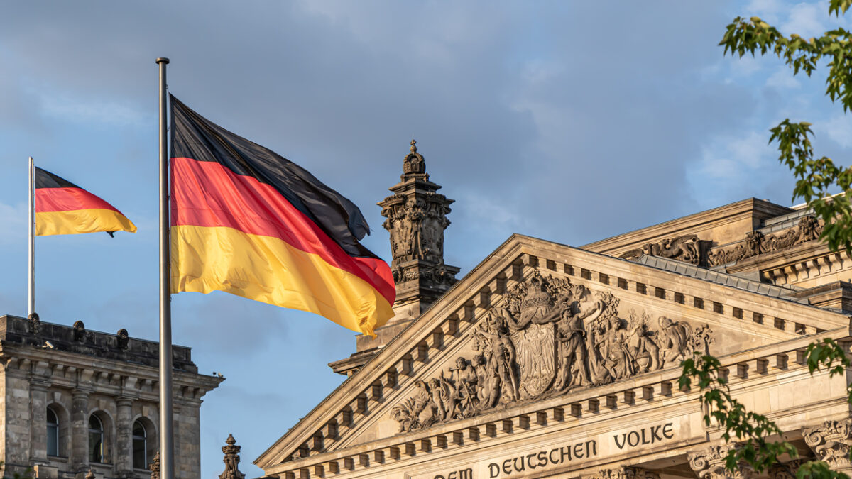 Federal Republic of Germany, German national flag at the Parliament building waving on the blue sky background, DE