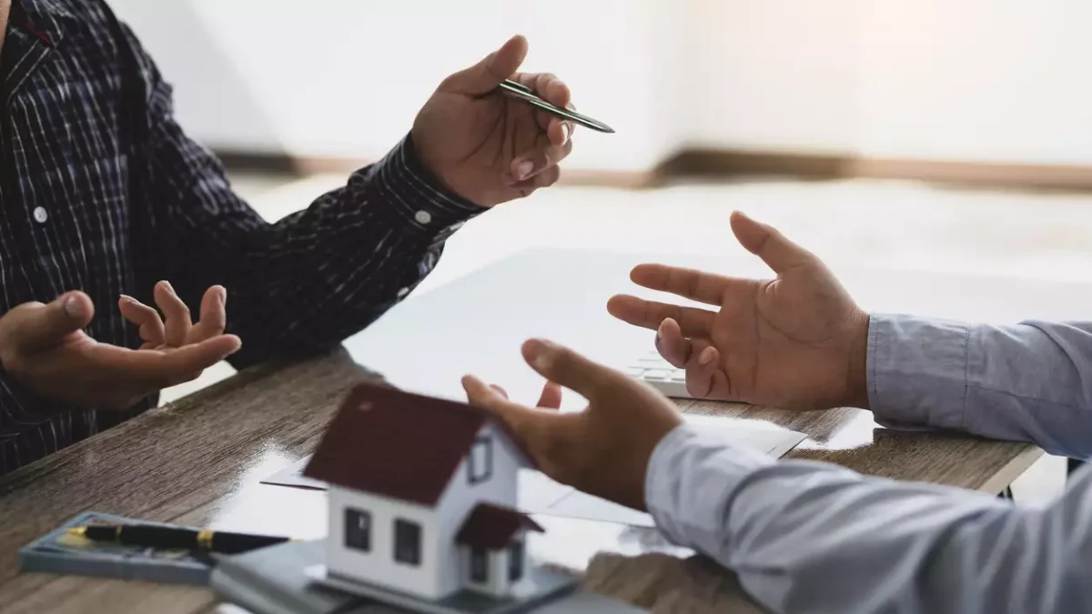 Real estate agents discuss home and land purchases with customers after agreeing to a home purchase and loan agreement.