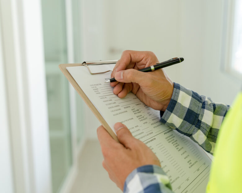inspector or engineer is inspecting construction and quality assurance new house using a checklist. Engineers or architects or contactor work to build the house before handing it over to the homeowner