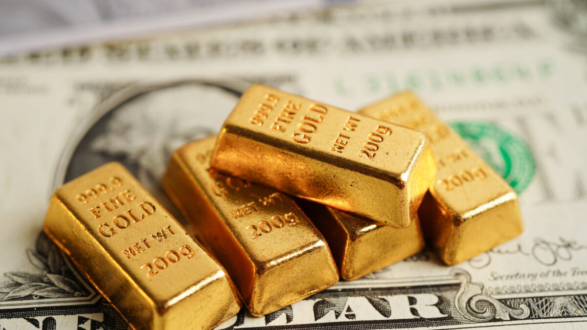 Gold bars on US dollar banknote money, finance trading investment business currency concept.