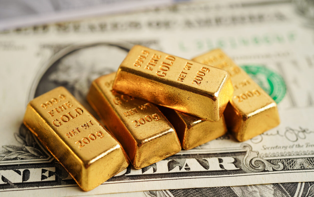 Gold bars on US dollar banknote money, finance trading investment business currency concept.