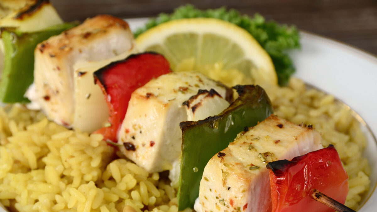 "A grilled shish kebab made of fresh swordfish, bell peppers and onions served over rice pilaf."
