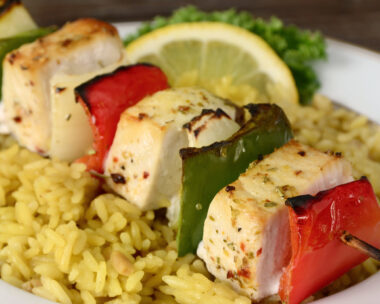 "A grilled shish kebab made of fresh swordfish, bell peppers and onions served over rice pilaf."