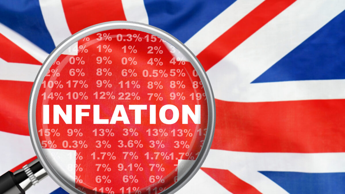 Magnifying glass focused on the word inflation on UK flag background. Hike interest rate. Inflation income crisis. Inflation, tax, cash flow and another financial concept in Britannia