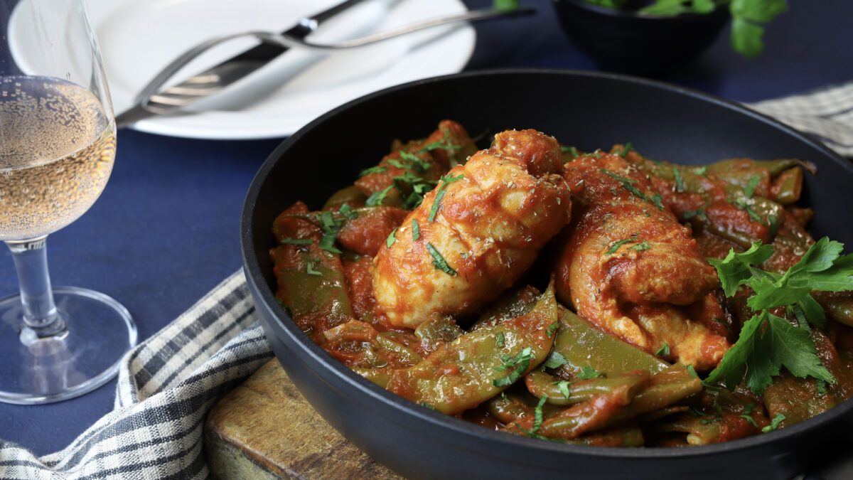 Chicken with snow peas and tomato sauce in a frying pan. Homemade cooking. Overhead view.