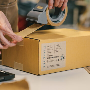 A small business warehouse worker owner packing and labeling eco friendly brown paper honeycomb wrapped with environmental Sustainability friendly paper biodegradable materials before shipping to customers,zero waster and plastic free concept