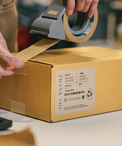 A small business warehouse worker owner packing and labeling eco friendly brown paper honeycomb wrapped with environmental Sustainability friendly paper biodegradable materials before shipping to customers,zero waster and plastic free concept