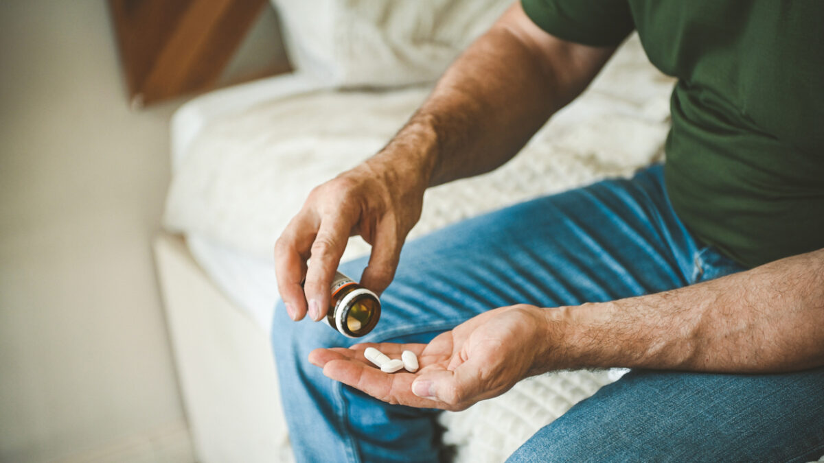 Mature adult man in cozy interior of bedroom ( taking medication)
