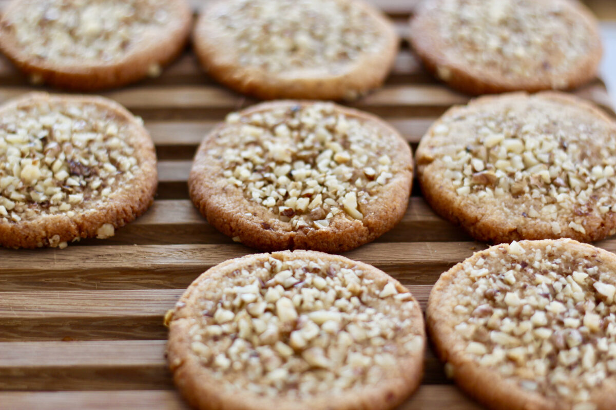 Freshly baked cookies with chopped walnuts topping on a wooden background