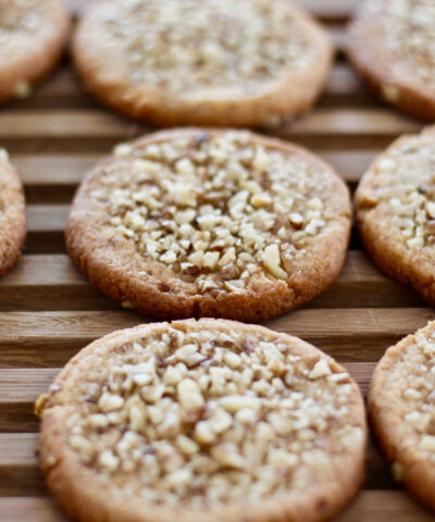 Freshly baked cookies with chopped walnuts topping on a wooden background