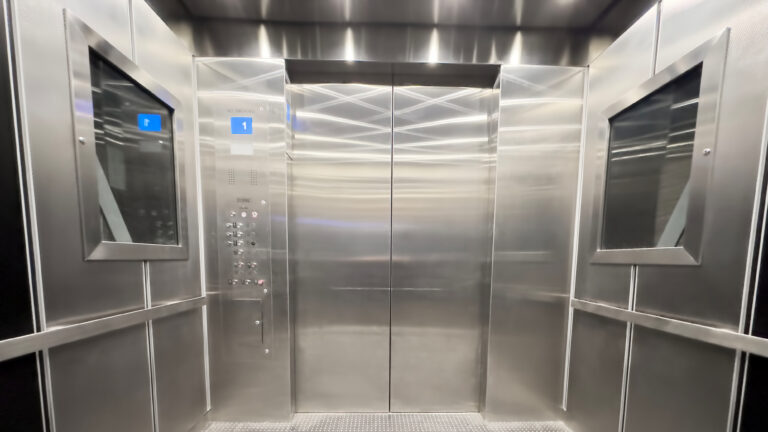 Inside view of an empty steel industrial elevator of an office