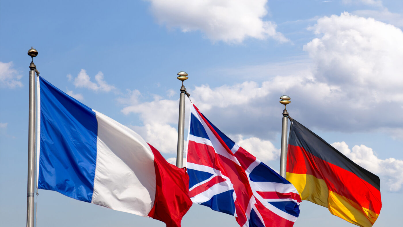 Flags of France, Great Britain and Germany against a blue sky