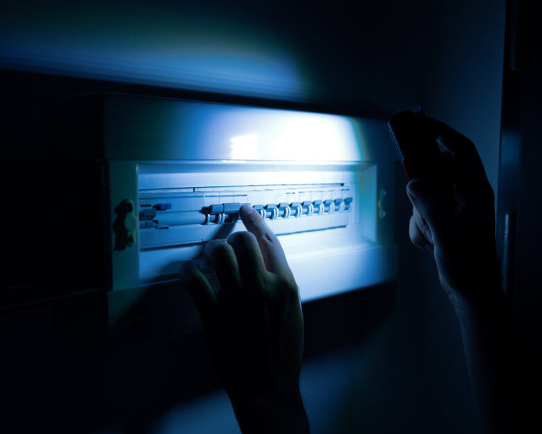 Investigate a home fuse box during a power outage. Blackout concept