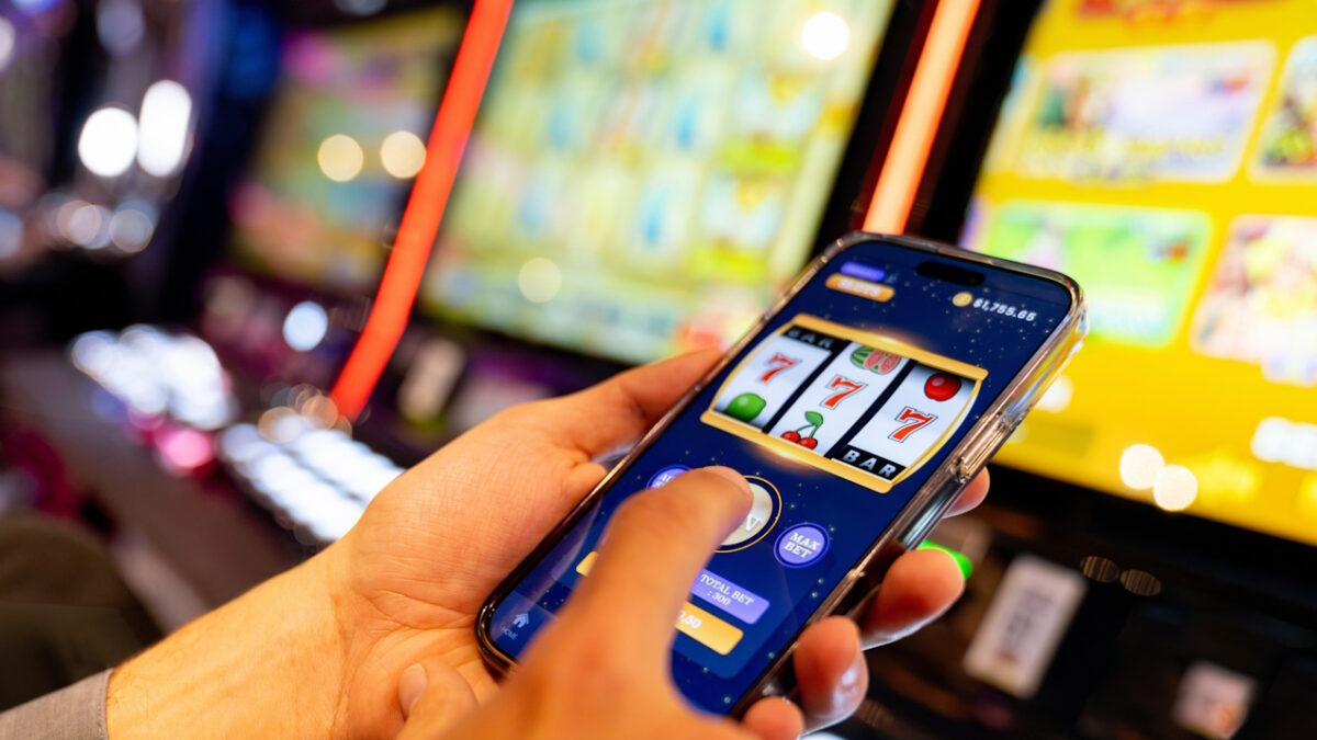 Close-up on a man playing a casino game using an app on a mobile phone - gambling concepts