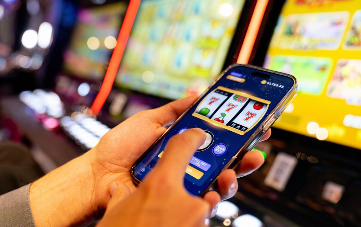 Close-up on a man playing a casino game using an app on a mobile phone - gambling concepts
