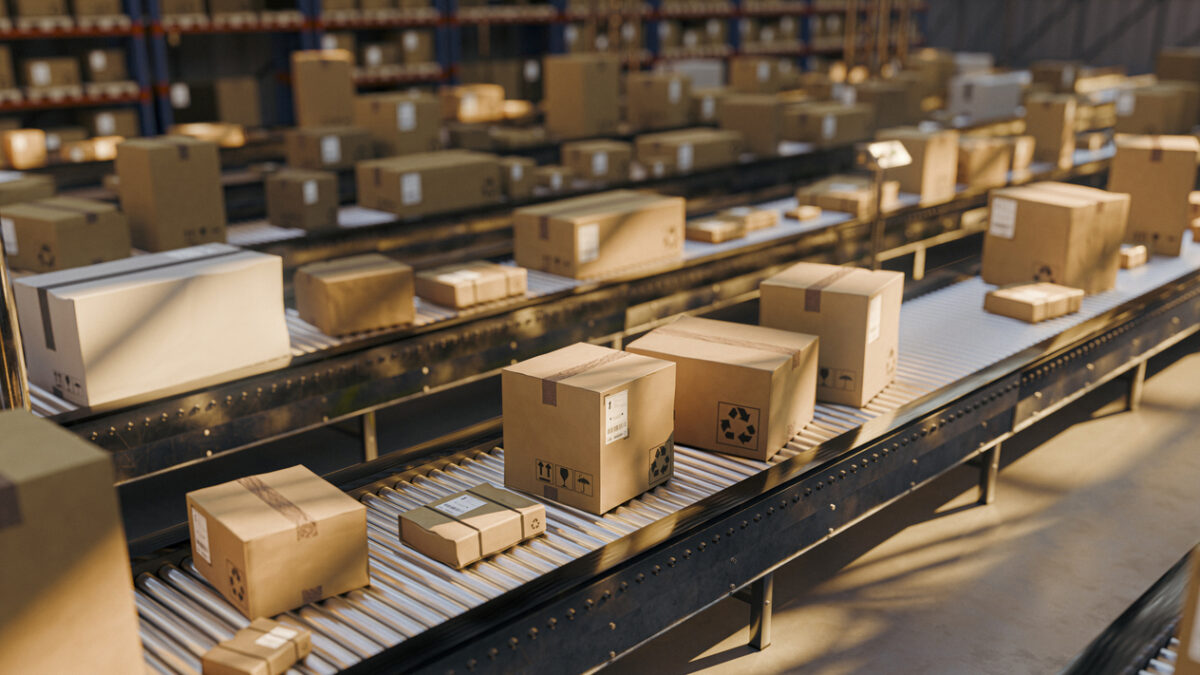 Rows of cardboard boxes and parcels travel along conveyor belts inside a large distribution warehouse, illustrating efficient shipping, order fulfillment, inventory handling and modern logistics operations.