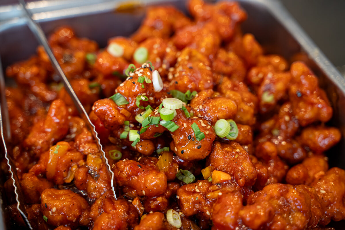 Close up of spicy glazed fried chicken in buffet tray.