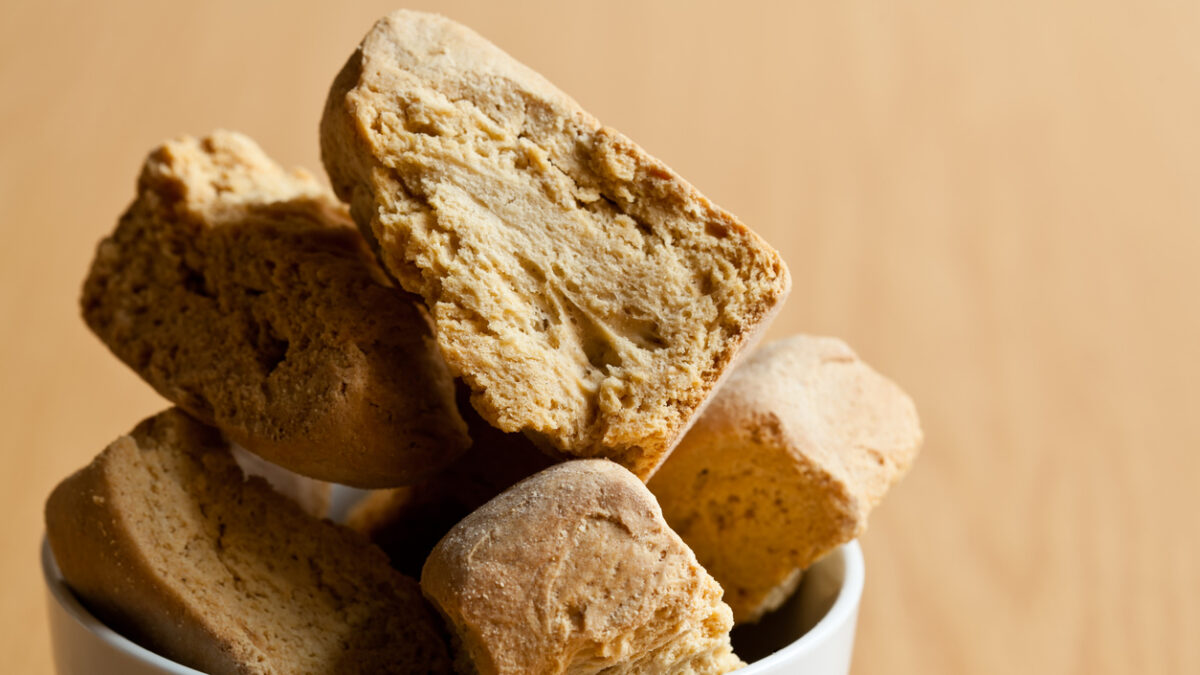 White Bowl containing fresh rusks on a wooden surface