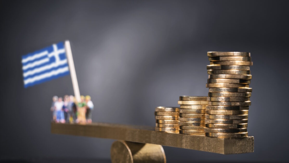 Seesaw with coins on one side and a group of people with Greek flag.