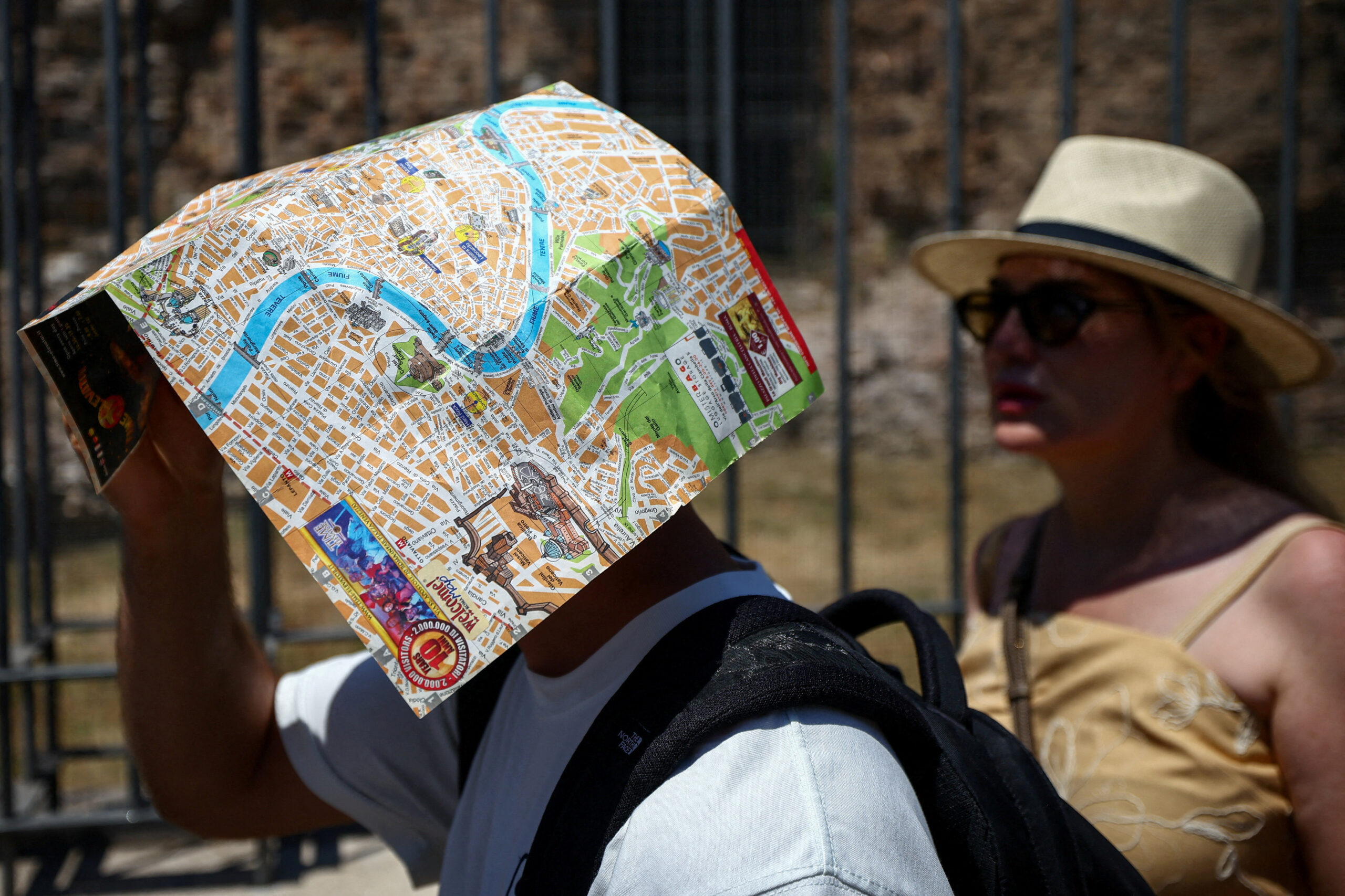 A tourist uses a map of Rome to shield their face from the sun beside the base of the Temple of Venus and Roma, opposite the Colosseum, during a heatwave in Rome, Italy, June 20, 2026. REUTERS/Guglielmo Mangiapane TPX IMAGES OF THE DAY