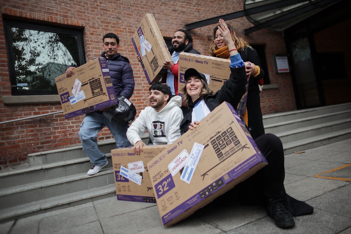 People pose with television sets they received for free after showing their U.S. visa denials during a promotion by television manufacturer Noblex for people unable to travel to the World Cup due to visa rejections, in Buenos Aires, Argentina, June 10, 2026. The stickers on the television boxes read "visa denied" and "TV Noblex approved".