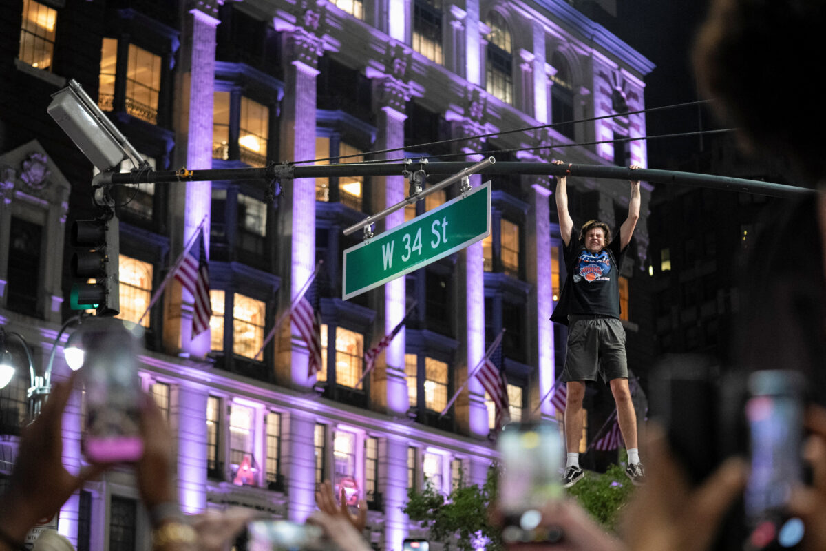 A fan celebrates the New York Knicks' win against the San Antonio Spurs in Game 5 of the NBA Finals, on a street near Madison Square Garden, in New York City, U.S., June 14, 2026.  REUTERS