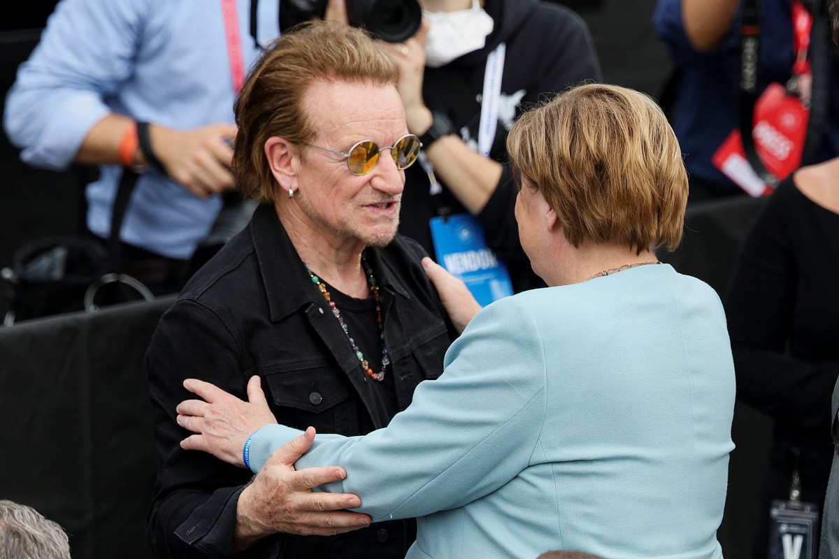Bono of U2 greets former German Chancellor Angela Merkel during a dedication ceremony for the opening of the Obama Presidential Center in Chicago, Illinois, U.S., June 18, 2026. REUTERS