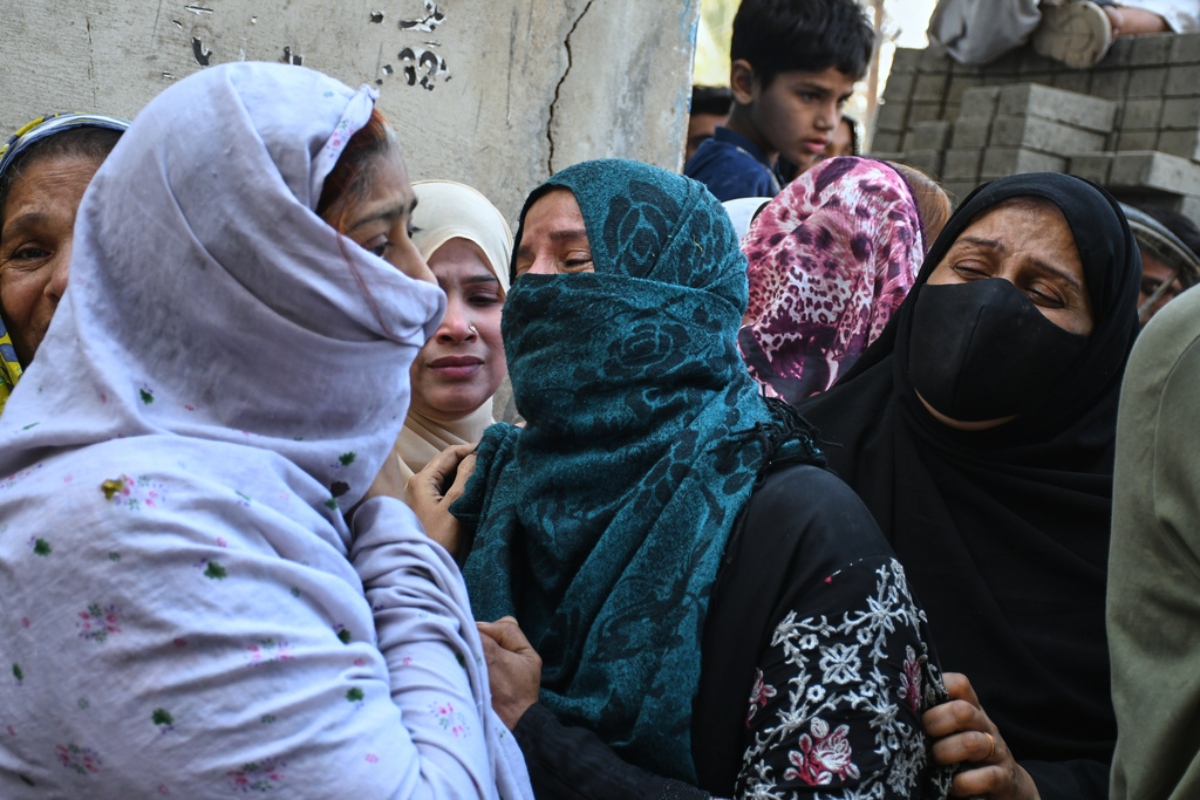 Women mourn over the death of their relatives near the site of a gas explosion in an apartment building, in Karachi, Pakistan, Thursday, Feb. 19, 2026.