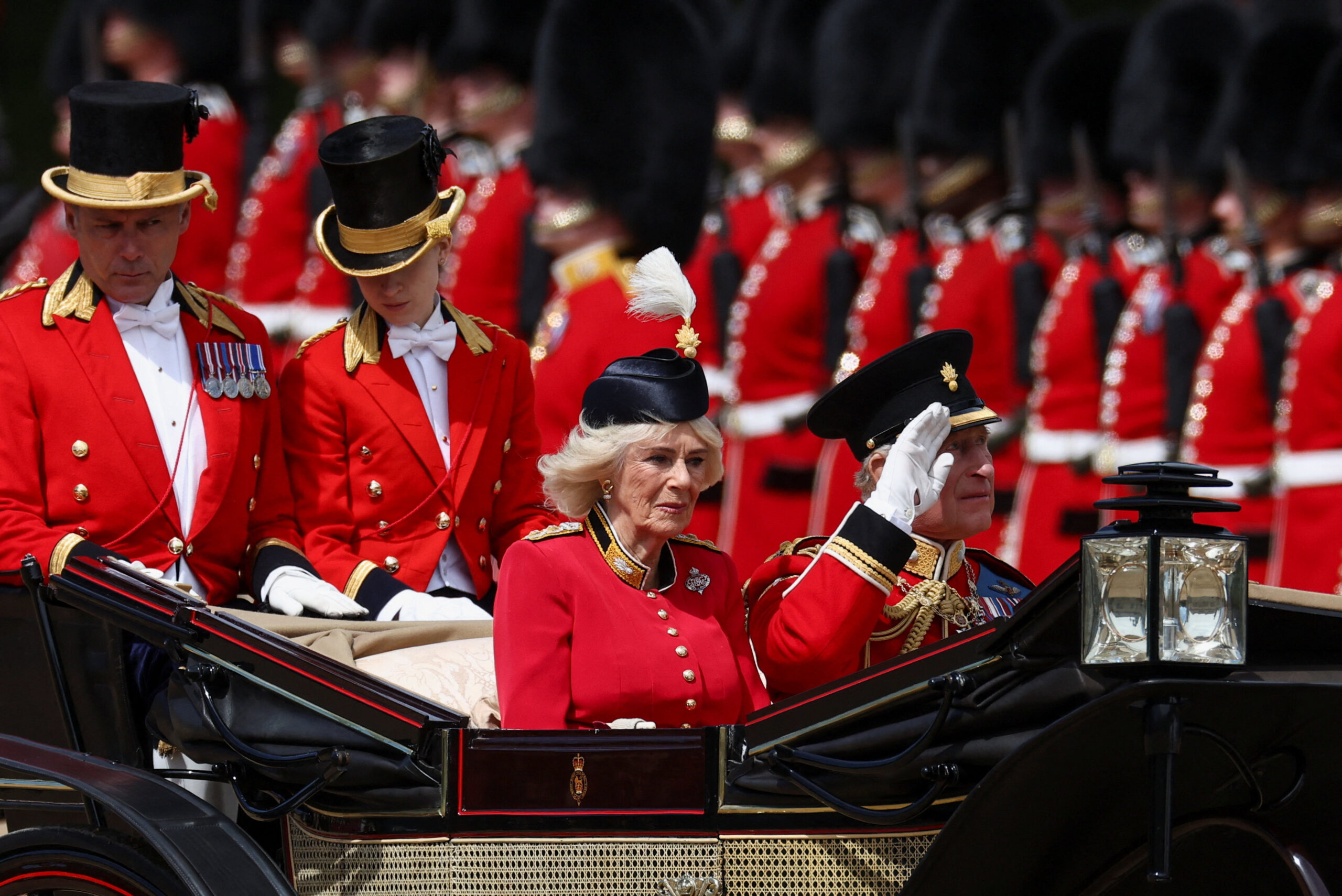 Britain's King Charles and Queen Camilla ride in a carriage during the Trooping the Colour parade to honour Britain's King Charles, as part of the official birthday celebrations, in London, Britain, June 13, 2026. REUTERS