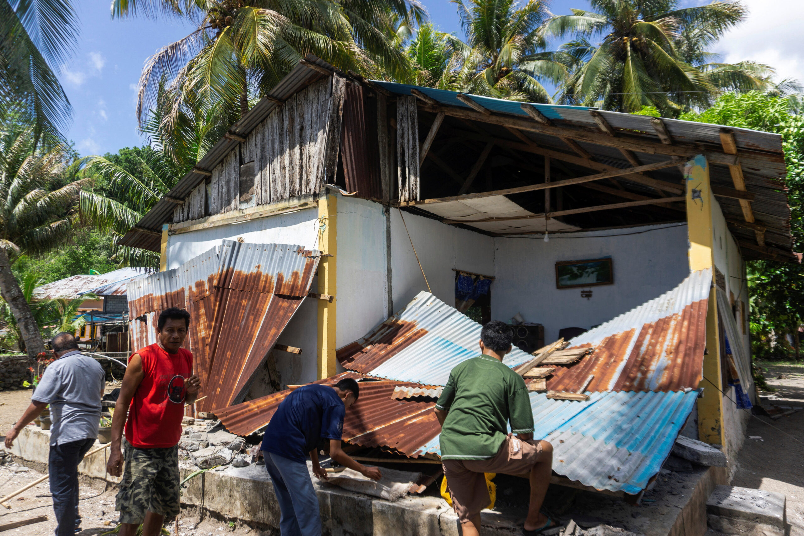 People collect their belongins from a damaged house following an earthquake off the southern Philippine island of Mindanao that was also felt in North Tabukan, Sangihe Islands regency, North Sulawesi province, Indonesia, June 8, 2026. REUTERS/Stenly Pontolawokang