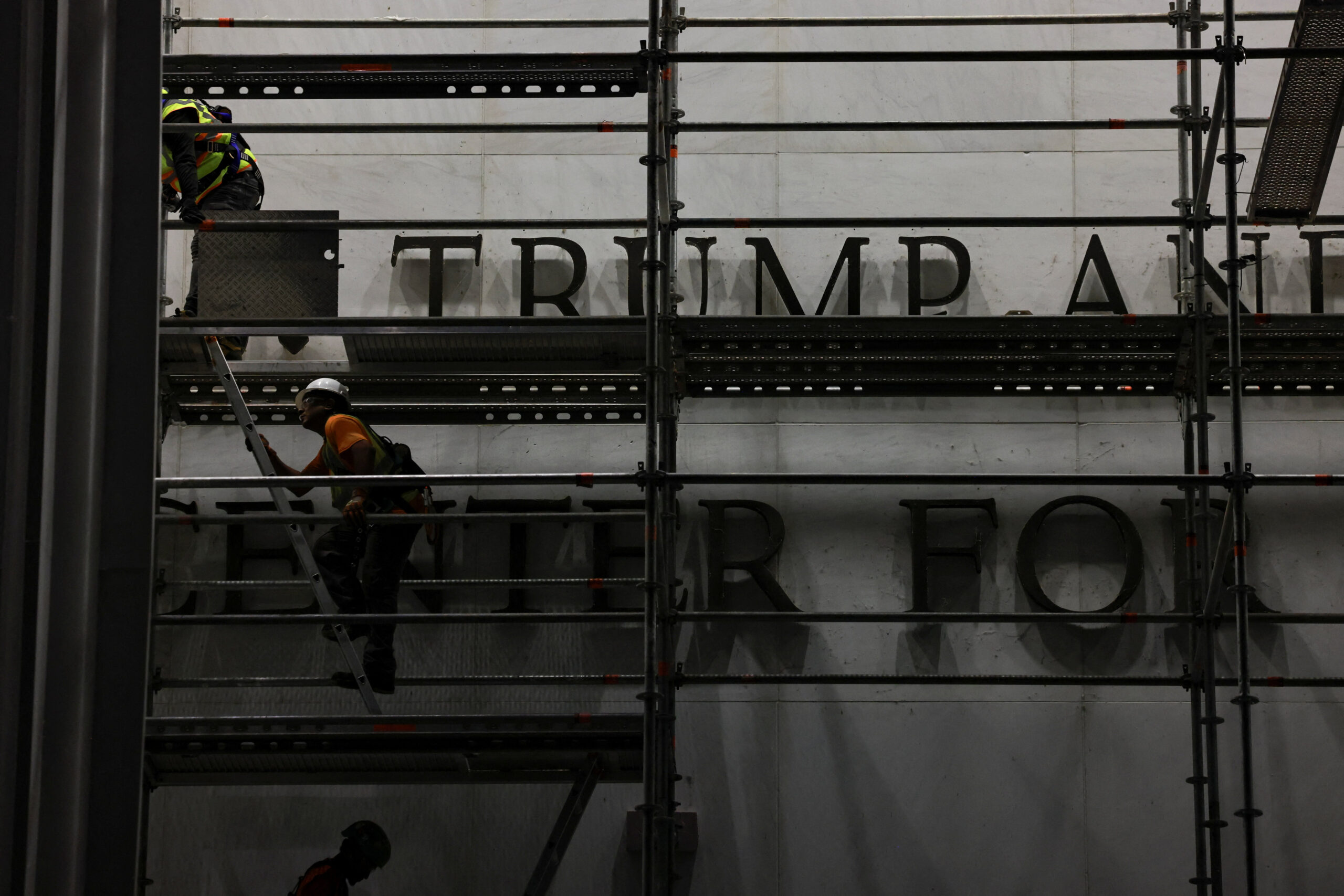 Workers prepare scaffolding ahead of removing lettering from the facade of the John F. Kennedy Memorial Center for the Performing Arts, following a federal judge’s order to remove U.S. President Donald Trump's name from the institution, in Washington, D.C., U.S., June 13, 2026. REUTERS/Anna Rose Layden