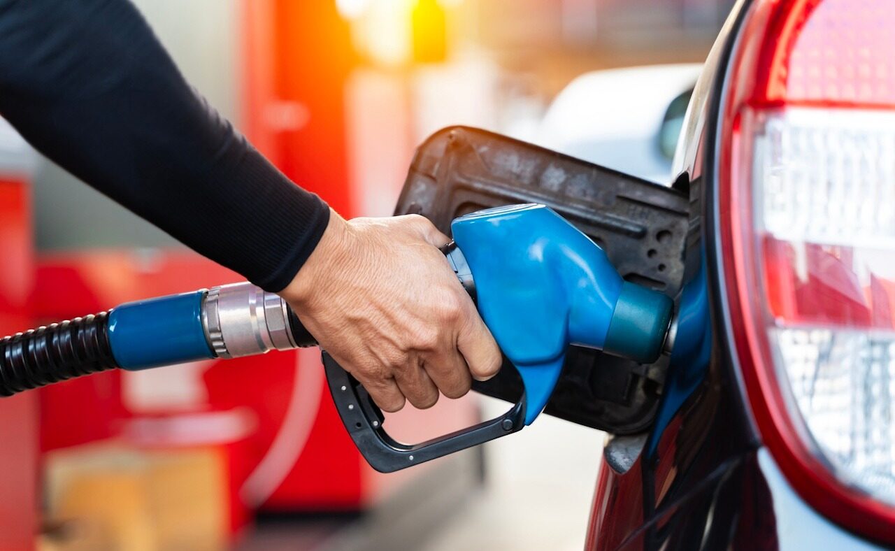 Refueling the car at a gas station fuel pump. Man driver hand refilling and pumping gasoline oil the car with fuel at he refuel station. Car refueling on petrol station. Fuel pump at station