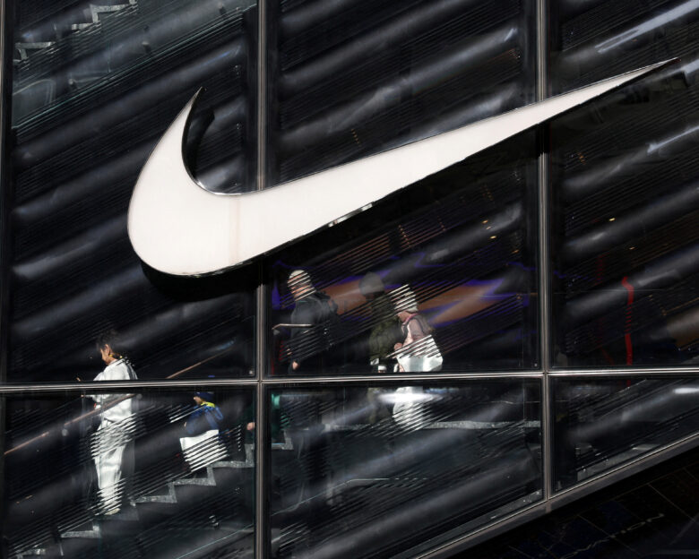 FILE PHOTO: People descend stairs inside a Nike store in New York City, U.S., April 2, 2025.