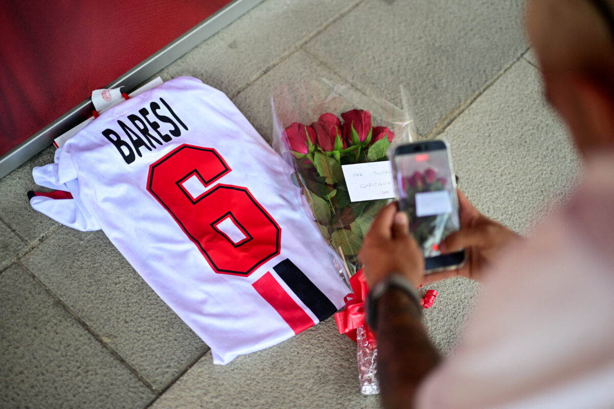 An AC Milan fan records a video of flowers and of a shirt with the name of former captain Franco Baresi at Casa Milan, following his death at the age of 66, in Milan, Italy, July 31, 2026. REUTERS
