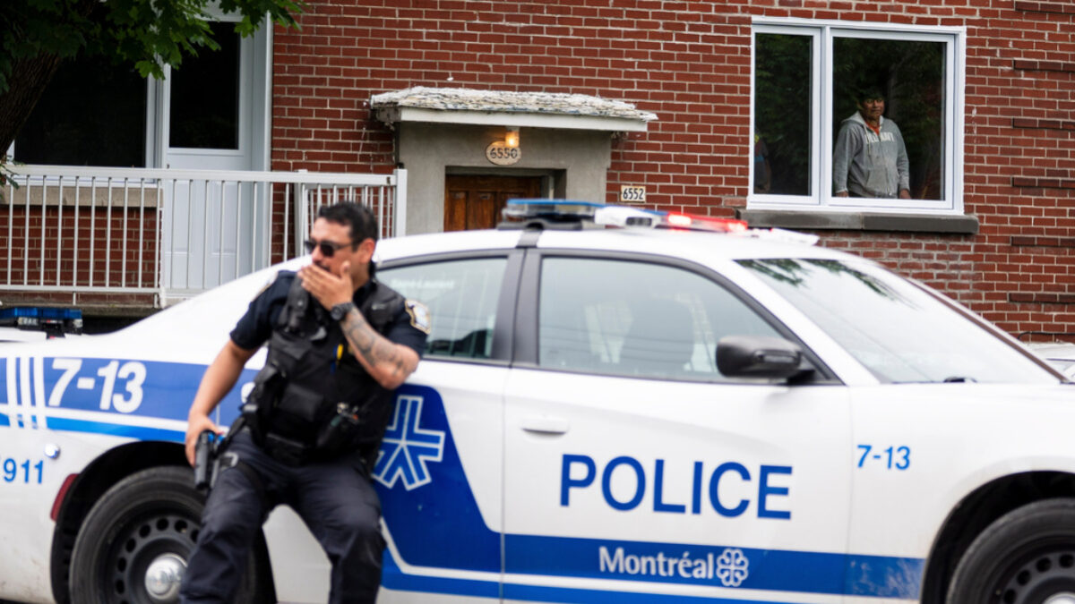 A residents looks on as Montreal police work the scene of a shooting in Montreal, Monday, June 22, 2026.