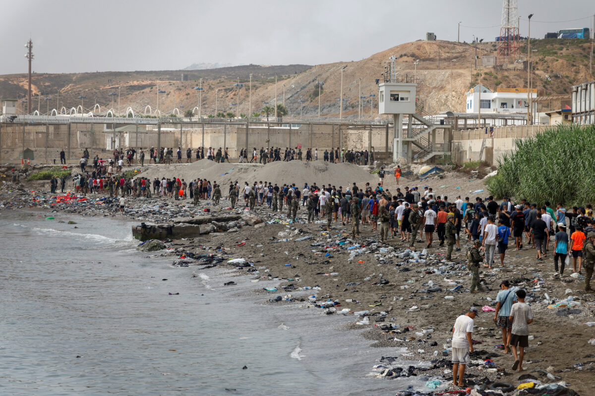People walk towards the border with Morocco leaving Spain, amid mass crossings of migrants on foot and by sea from Morocco into Spanish territory, in Ceuta, Spain, July 31, 2026. REUTERS